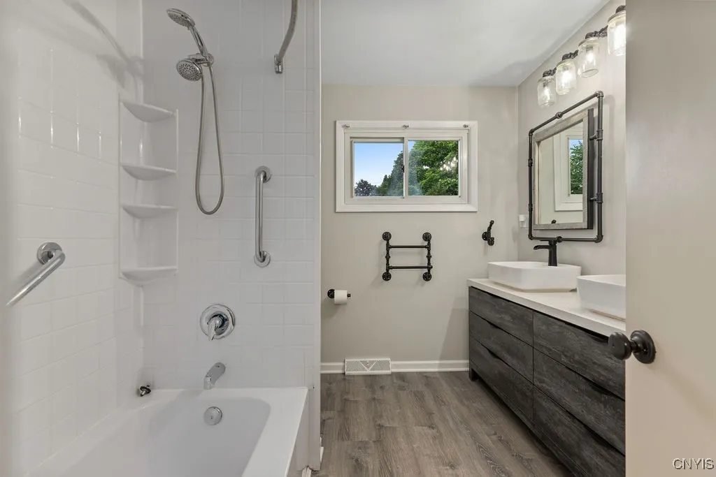 This updated full bathroom is on the same level as the bedrooms. It features double sinks and luxury vinyl flooring.
