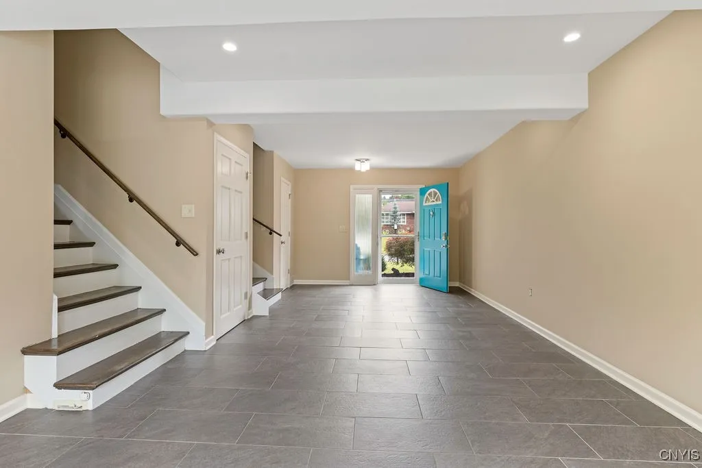 This view of the huge foyer/entryway shows how the area stretches from the sliding glass doors to the turquoise front door.