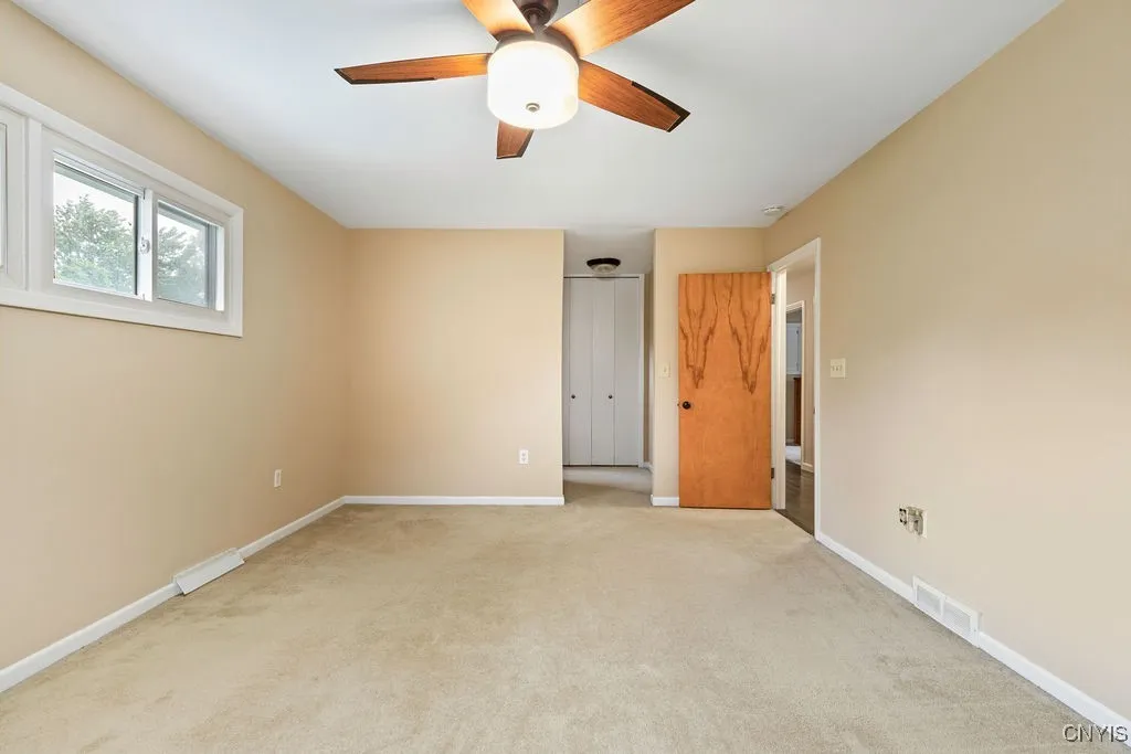 This view from one end of the main bedroom shows the closet and bathroom entry.   To the right is the door to the hallway.