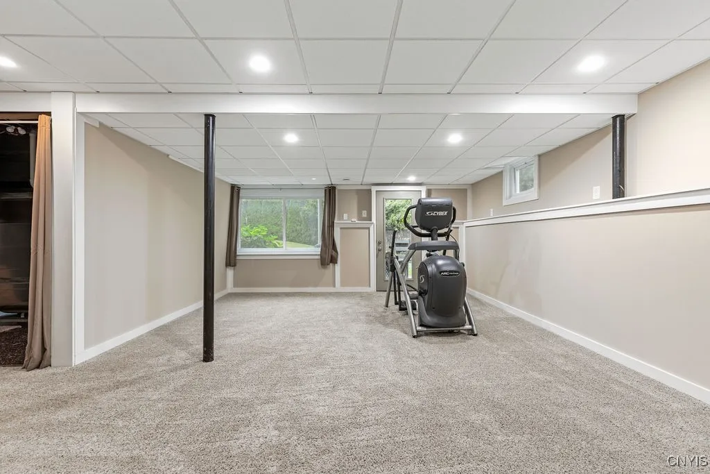 Front-to-back lower level family room with new carpet,  new paint and the walk out door to the back yard.