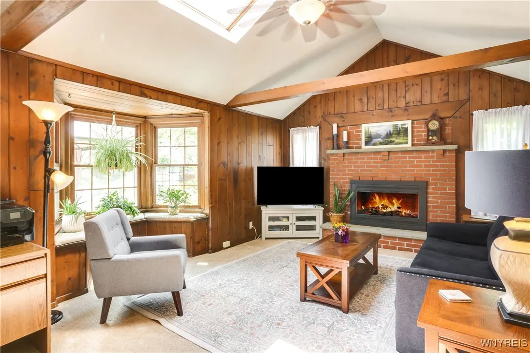 Family room with gas fireplace, cathedral ceilings and skylight.   Bay overlooks the yard and gardens/inground pool