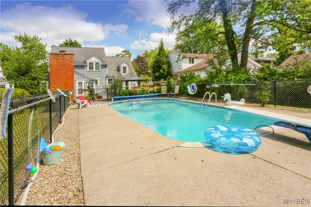 View of the pool from the back fence of the pool area.  There is plenty of safe play area of grass and patio area. Fencing is just around the pool and was put in by City Fence in 2023.