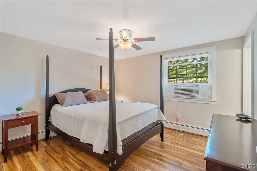 The large primary bedroom features a pretty overhead light/fan fixture while we see that the same terrific Pergo floors are present on this level.
