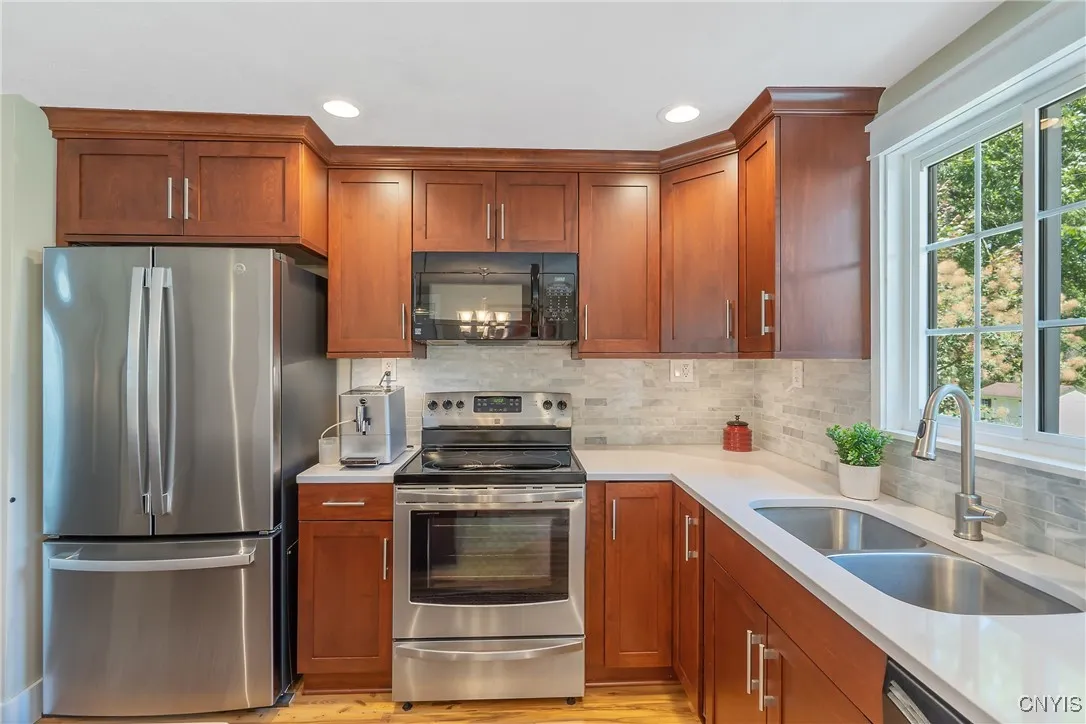 Here we see the chef\'s territory as the stainless oven/cooktop has plentiful countertop space on its sides steps from the double-basin stainless sink. And note the 1-year-young stainless steel refrigerator!
