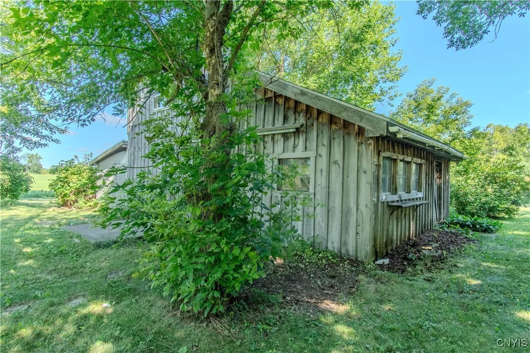11/2 Story building behind house with concrete pad and electric