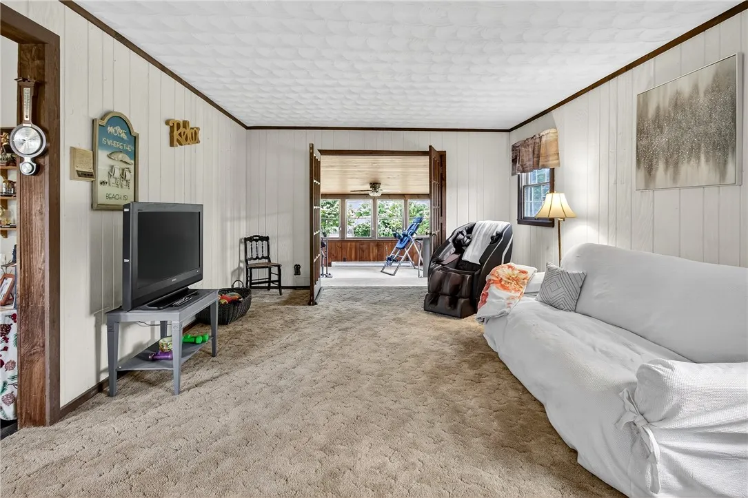 The living room off the front hallway leads to the enclosed heated porch