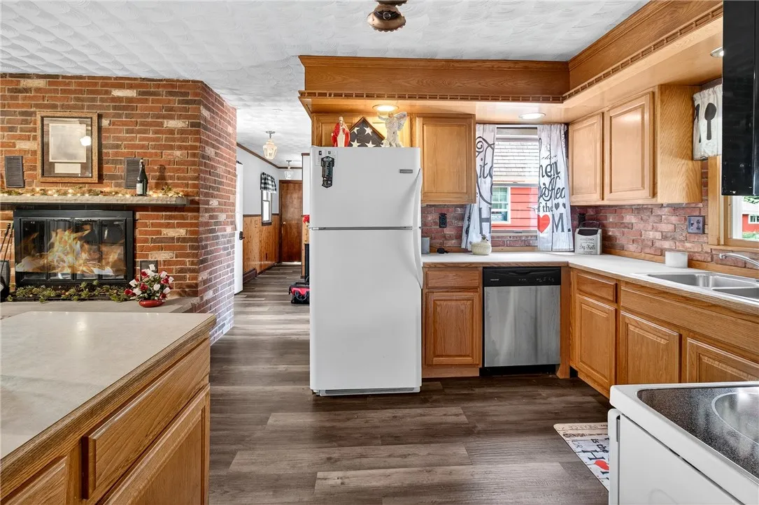 The kitchen open to the family room which features a wood burning fire place