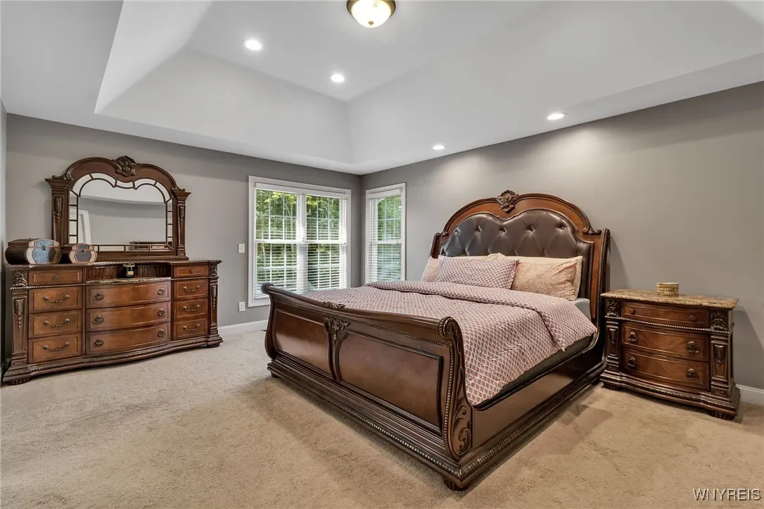 Primary bedroom with tray ceiling, recessed lighting, ensuite bath and double walk in closets w/Custom Closet system.
