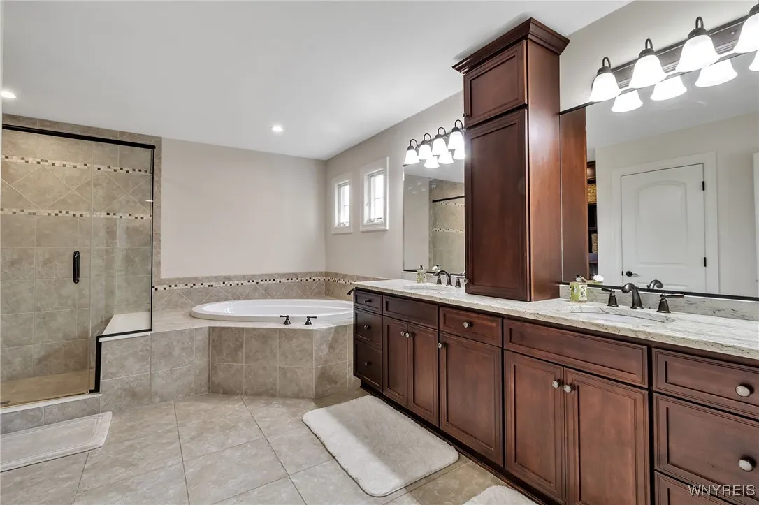 Primary bath is stunning with double sinks, granite counters, tub and step in shower with seat!