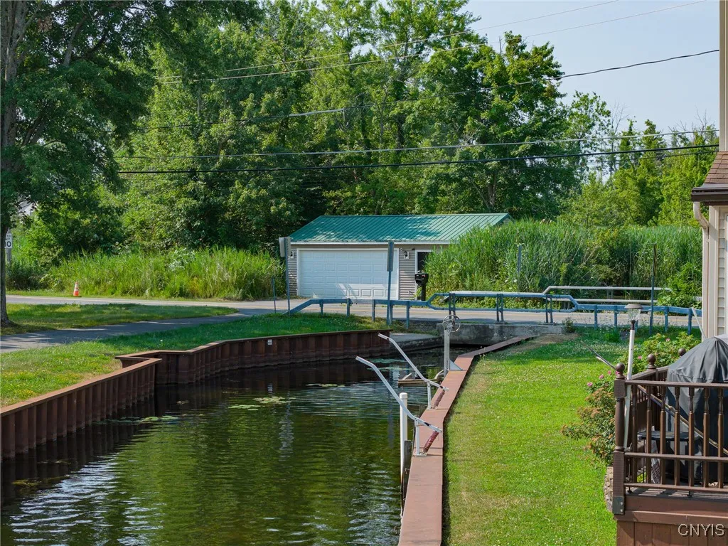 A view of the canal that borders the lot on one side and the 2.5 car Garage across the street.  The Garage is also vinyl sided with a metal roof and features a convenient, separate storage room on the side.