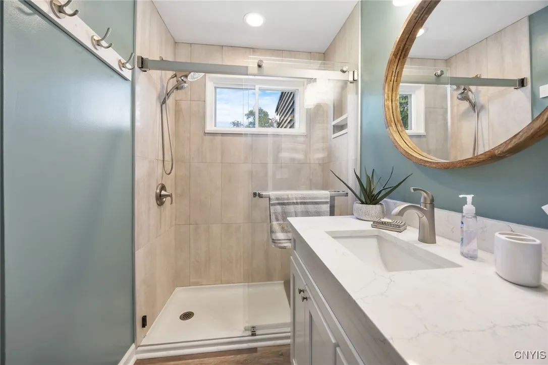 The updated Full Bath boasts a walk-in shower w/glass doors & ceramic tile surround, a new solid surface vanity, and LVP flooring.