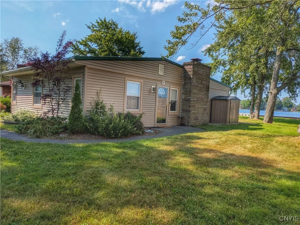 The main entrance is on this side of the house which features low maintenance landscaping, vinyl siding and metal roof.  The handy Garden Shed is set on a concrete pad for more stability.