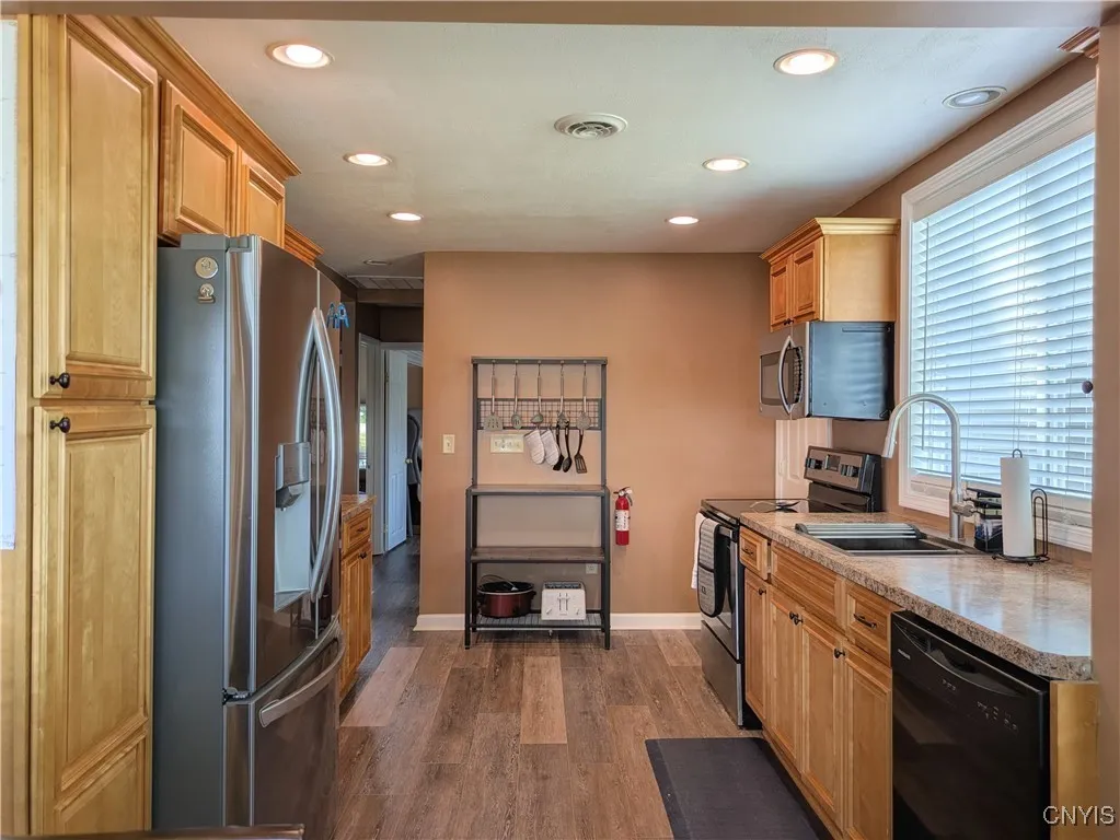 The fully equipped Kitchen boasts easy-care LVP flooring, plenty of maple cabinetry, SS appliances and sink below the big picture window looking out to the canal side of the house.