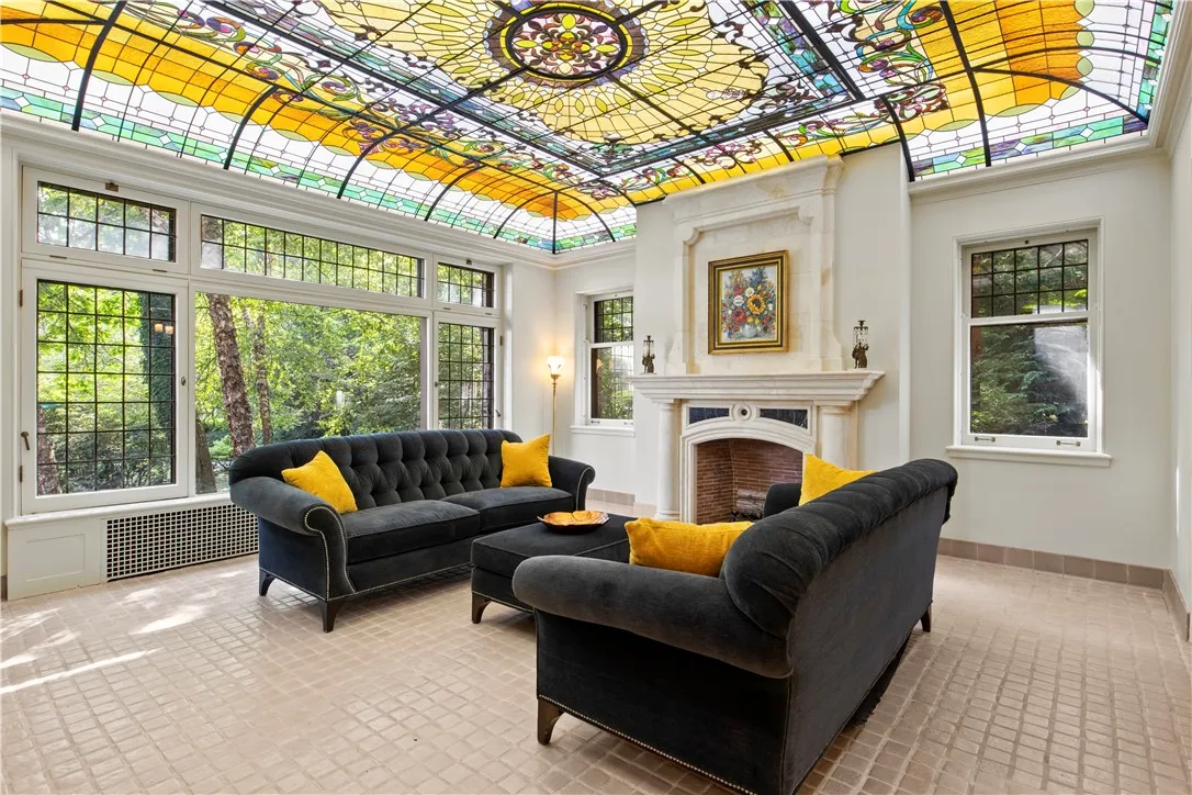 The sunroom, features a stunning Valerie O’Hara/Pike’s trans-illumination leaded glass ceiling, and an original tile floor.
