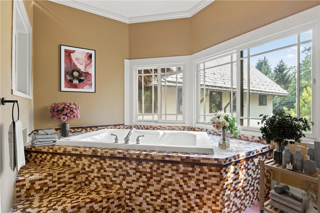 A separate spa room in the master suite is accessed through beautiful leaded doors. The space is enhanced by stunning views and an original alabaster light fixture, creating a perfect haven for relaxation.