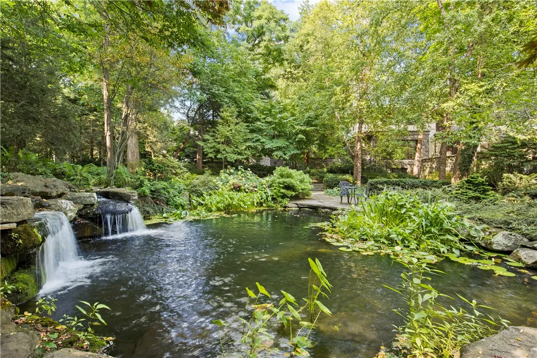 Stunning landscaping surrounds the scenic pond.
