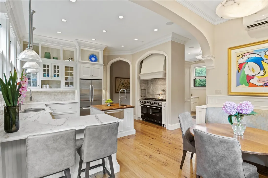 A cozy, curved, padded banquette offers views of the terrace through the French doors, inviting al fresco dining on the slate veranda.
