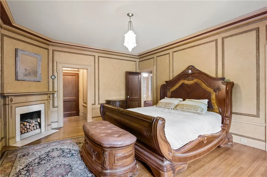 The primary bedroom is pretty as a picture with a ornamental fireplace.
