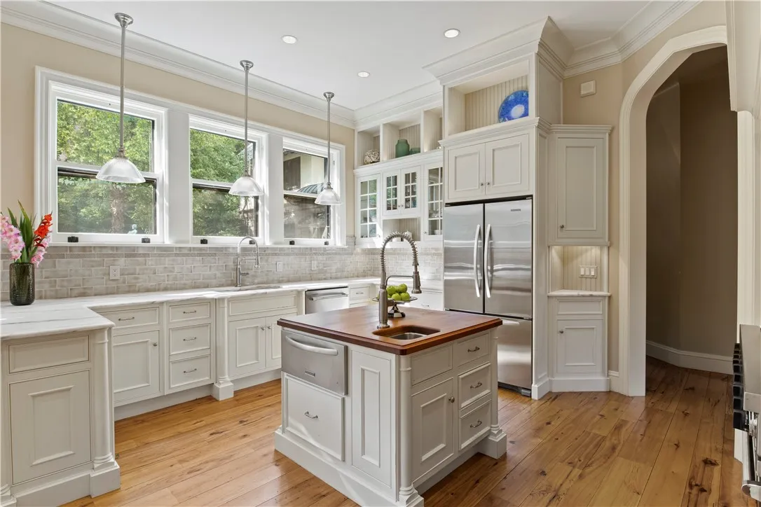 A breakfast bar, glass display nooks, and a six-burner/grill Viking range with double ovens and a warming oven rounds out the attractive features of the kitchen.
