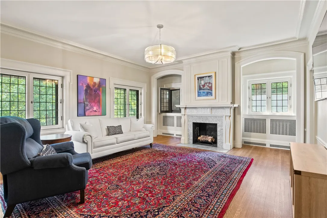 The media room with ornamental carved mantle fireplace overlooks the rear yard.
