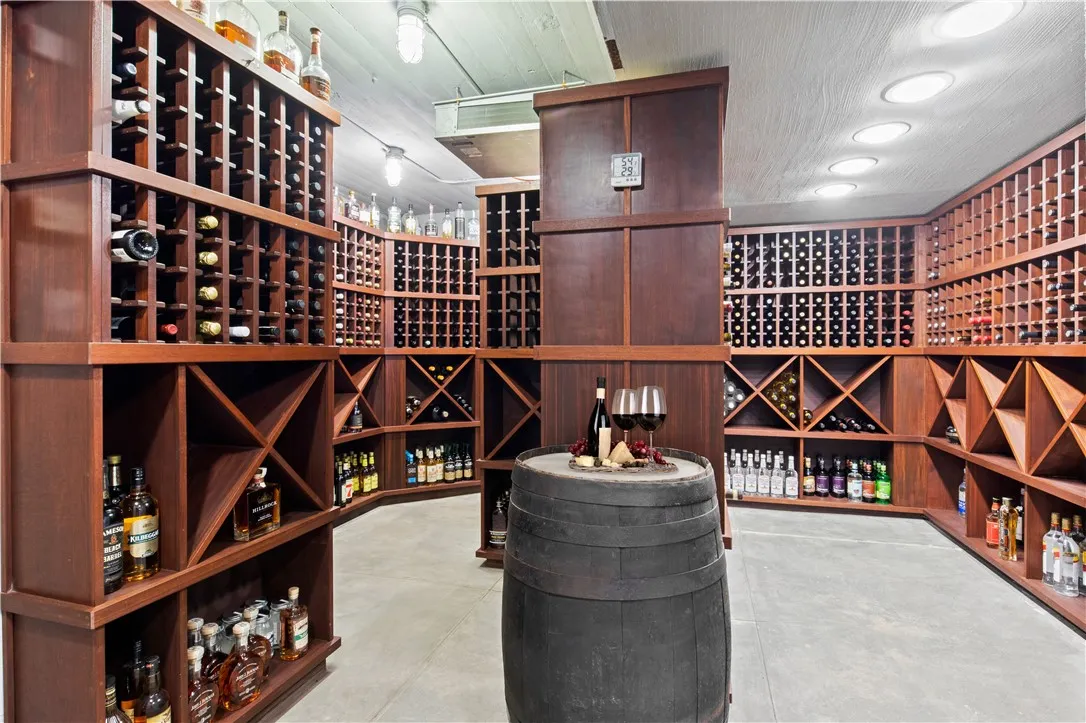 The impressive wine cellar, with a capacity of 2,500 bottles, is meticulously controlled for both temperature and humidity, and is entered through a custom-painted bank vault door.