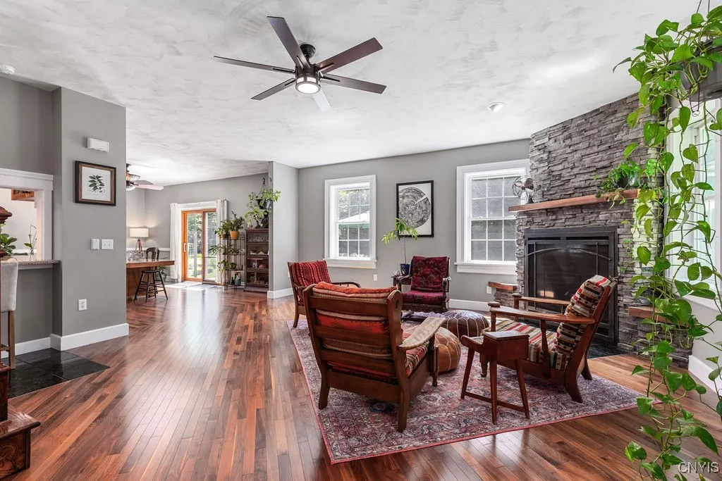 aAnother view of the first floor showcases the cozy fireplace gathering room—a perfect spot to relax and enjoy the warmth and charm of this beautiful home.





