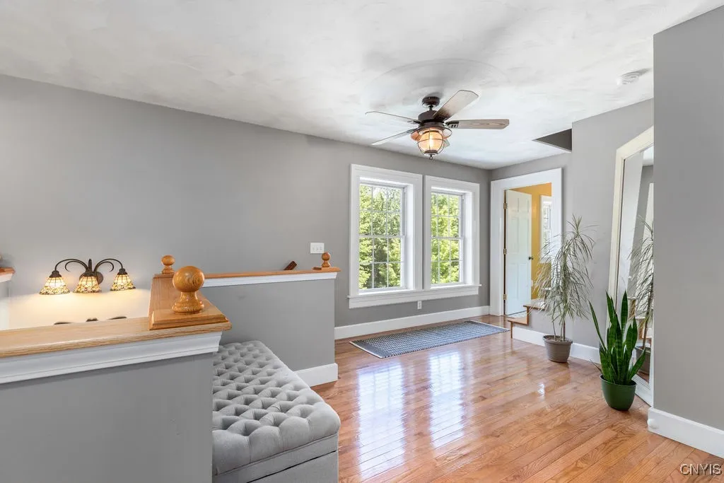 A large, open second-floor hallway featuring solid oak floors, plenty of windows, and a half-wall design that creates a bright, spacious, and functional area—such a great space!