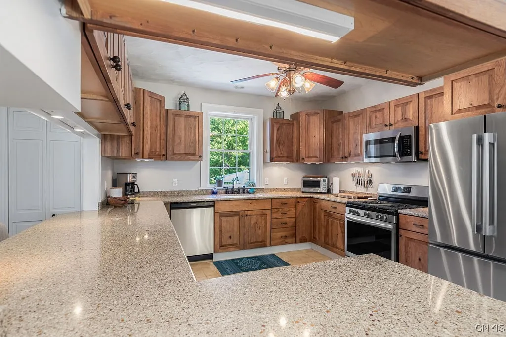 This huge kitchen is perfect for the whole family to gather and prepare meals together. It features an abundance of solid hickory cabinetry, plenty of counter space, and newer stainless steel appliances—including a gas oven and stove, ideal for the chef in the family.