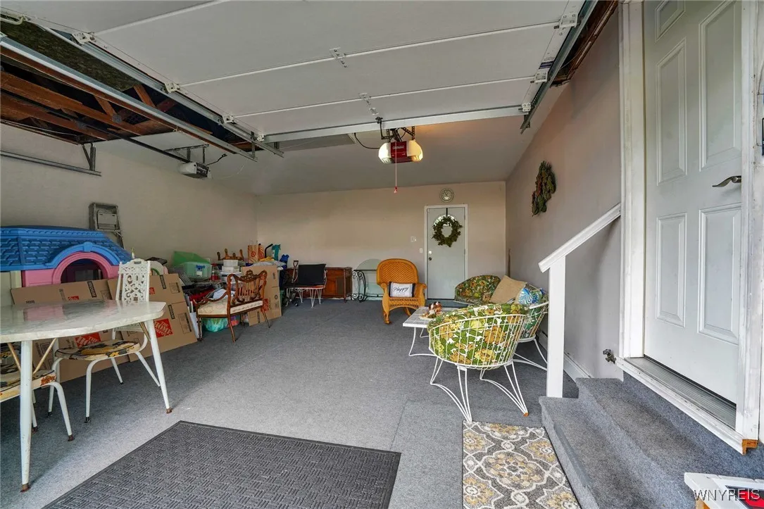 GARAGE SERVES AS A SUMMER SITTING RM WITH INDOOR/OUTDOOR CARPET--REAR SERVICE DOOR LEADS TO BACKYARD AND DOOR ON RIGHT LEADS TO FRONT FOYER AREA OF HOME
