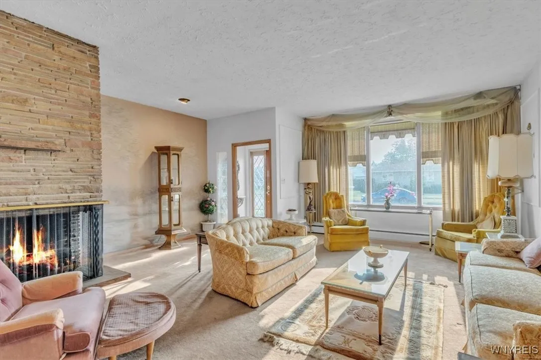 Large front window lets in plenty of light. Also note recessed lighting in the ceiling and enjoy the wood converted gas fireplace when you want a cozy moment.
