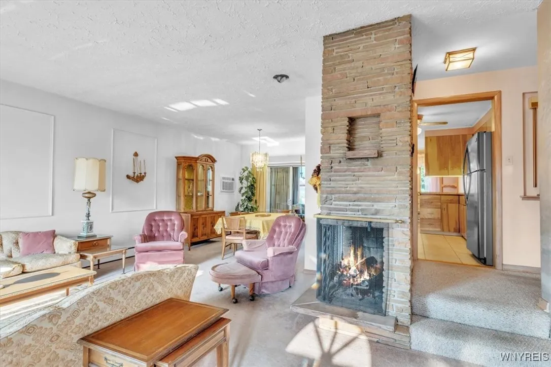 Spacious living and dining room with wall to wall carpeting makes this home very comfortable. Also  the wood burning fireplace with gas insert.