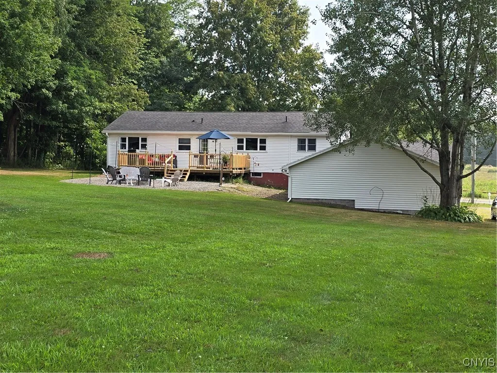 Another view of the house, deck, fire pit and GINORMOUS garage to the right.