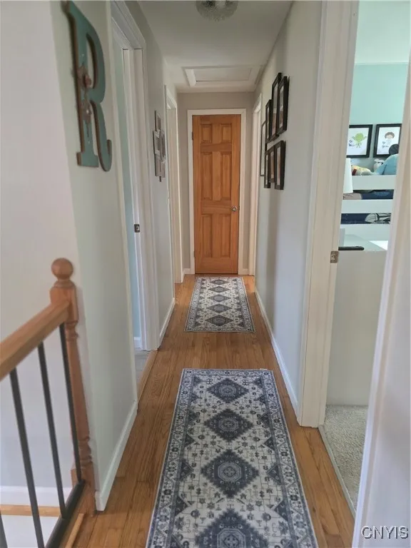 The hallway also has hardwood floors and they are accented with runners in the same relaxing hues that are found throughout this home.