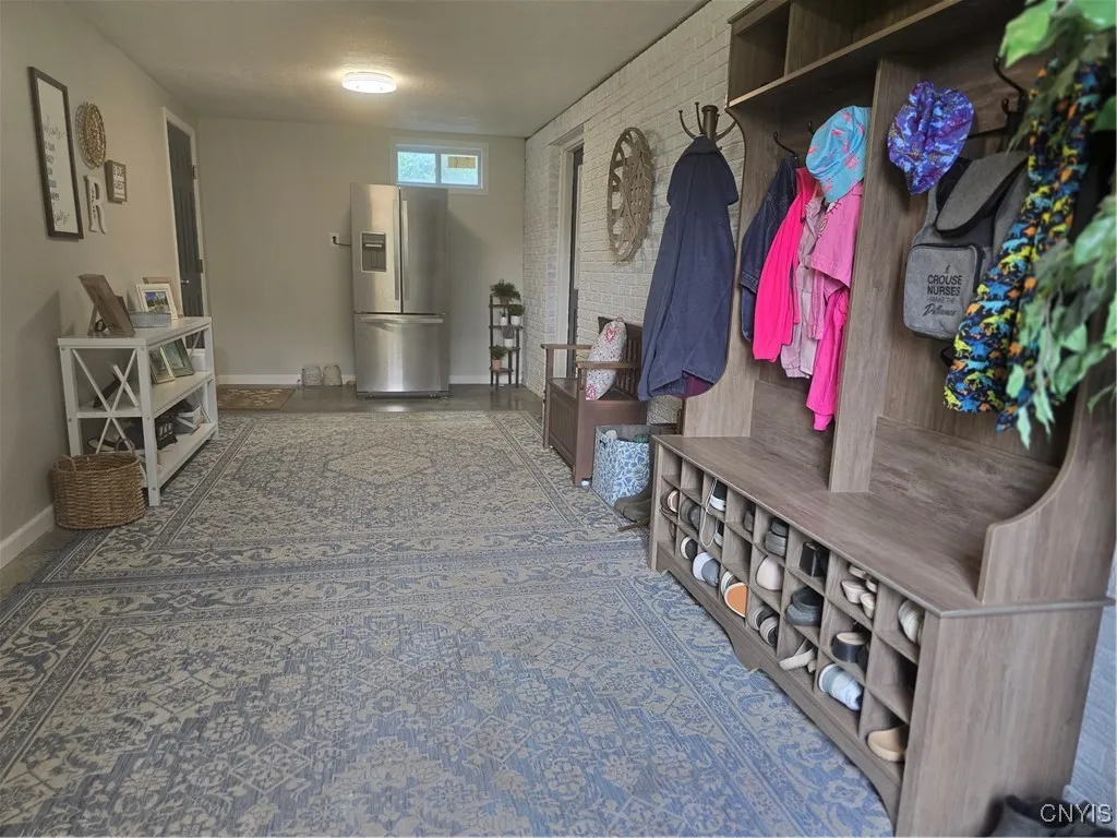 As you can see, this room is very efficient--lined with coat & shoe racks and benches to assist in the process of removing outerwear before entering..especially when it's muddy or snowy !! :-) And perfect space for the extra refridgerator. The door on the right enters into the somewhat finished basement, while the door on the left goes into the garage.
