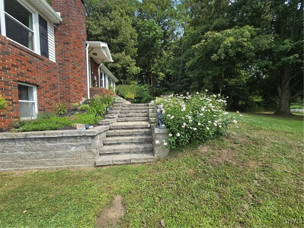 The beautiful stone steps are surrounded by perennials bursting with color and welcoming all to the formal front door.