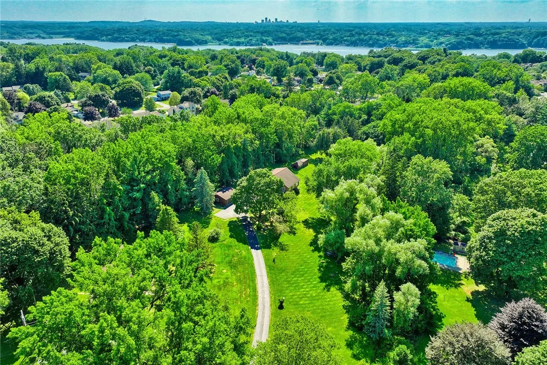 Overhead views of Irondequoit Bay and the city! ...Private and park-like, this home is set well off the road