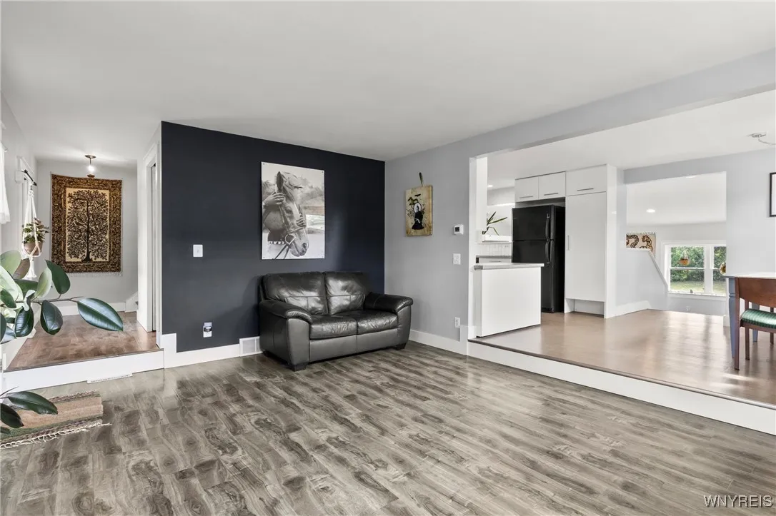 View showing multiple areas. (Come up the steps from the family room into kitchen area and then move into living room, pass the half bathroom before going upstairs). View showing multiple areas. (Come up the steps from the family room into kitchen area and then move into living room, pass the half bathroom before going upstairs).