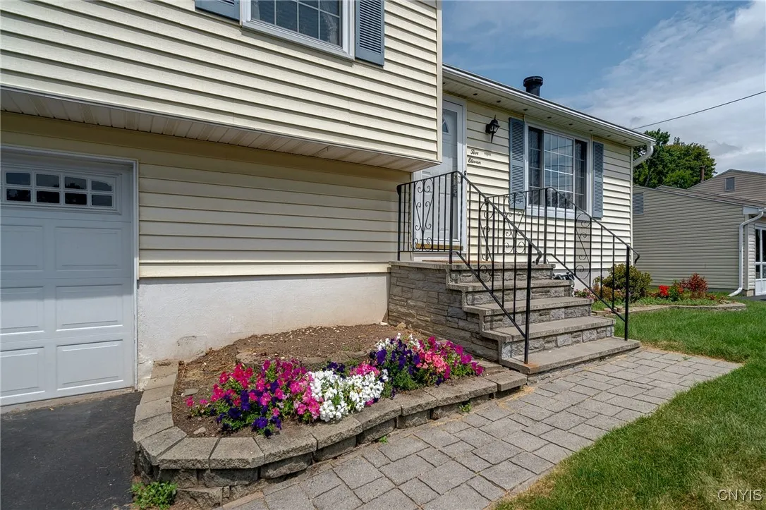 Beautiful paver driveway and landscaping lead you into the home