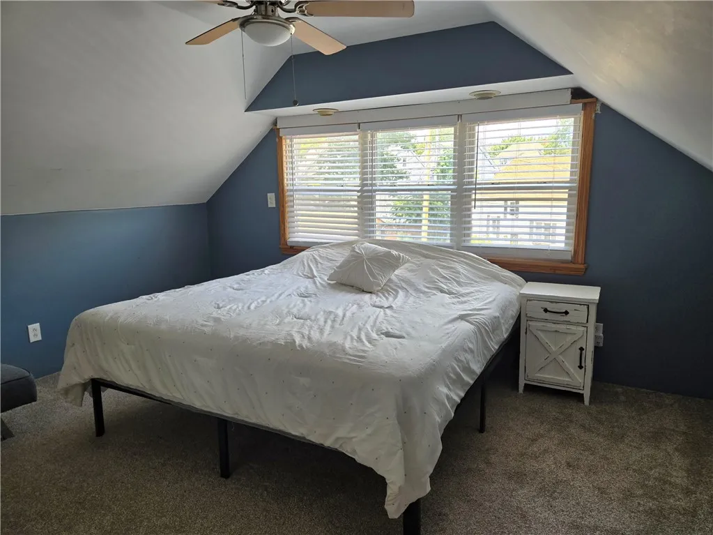 There is a ceiling fan and several windows.