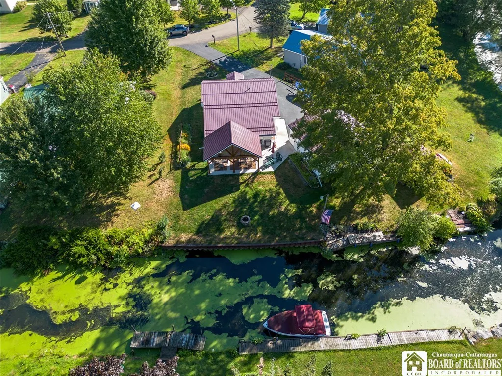 Ariel view of the property along the canal with a brand new pavilion with glass inserts at the top.  A private deck/dock allows for easy access into Chautauqua Lake via this canal.