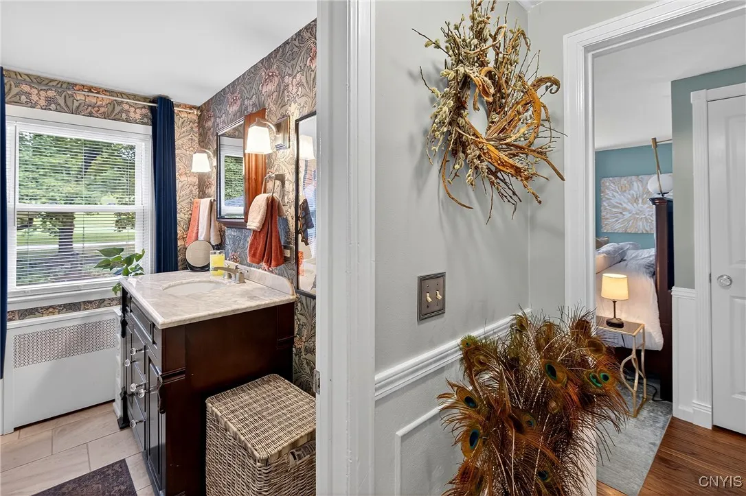 Hall outside full bath with view of bedroom entry