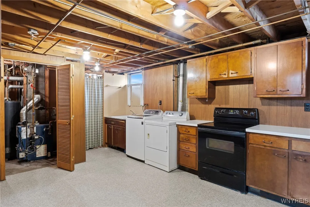 basement laundry room canning kitchen includes washer, dryer, stove and freezer