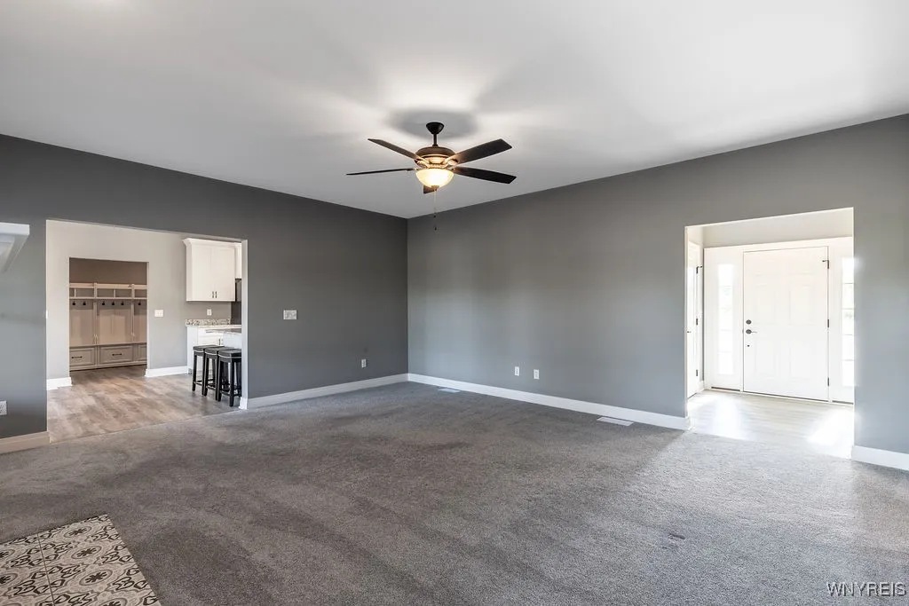 Living room looking into kitchen and front entrance