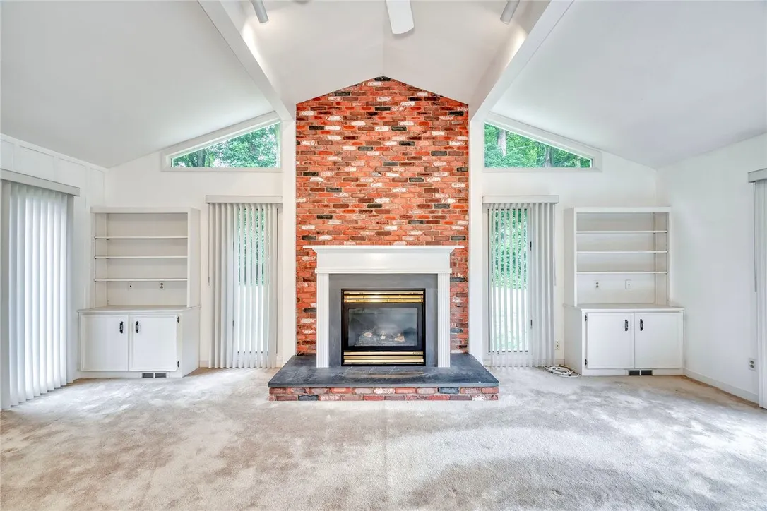 The cathedral family room is really the pièce de ré·sis·tance w/built in bookcases, gas fireplace and gorgeous windows!