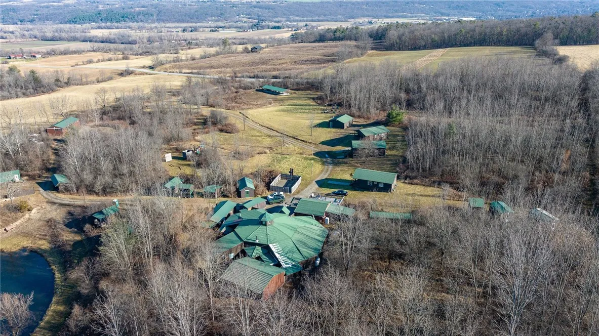 Located on 48+ acres with a stocked pond, bunk houses, cabins, barns, and much more!