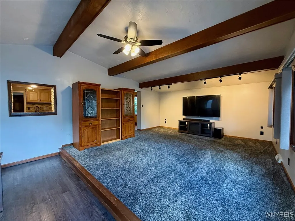 Extra-large family room features a charming vaulted wood beam ceiling and recessed lighting