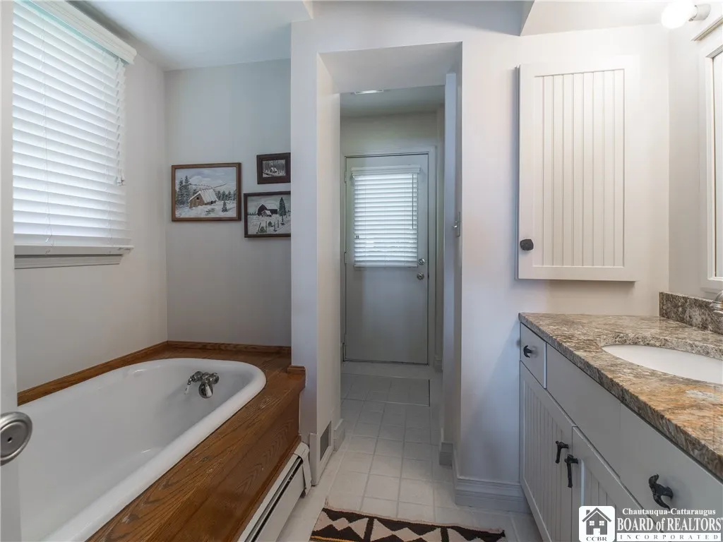 Bath with tub, granite vanity top... door to the covered porch