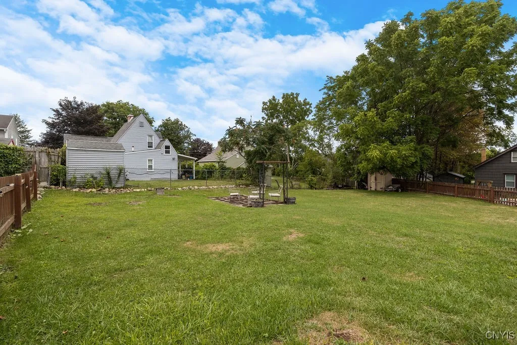 The fully fenced backyard includes 2 sheds and a fire pit area.