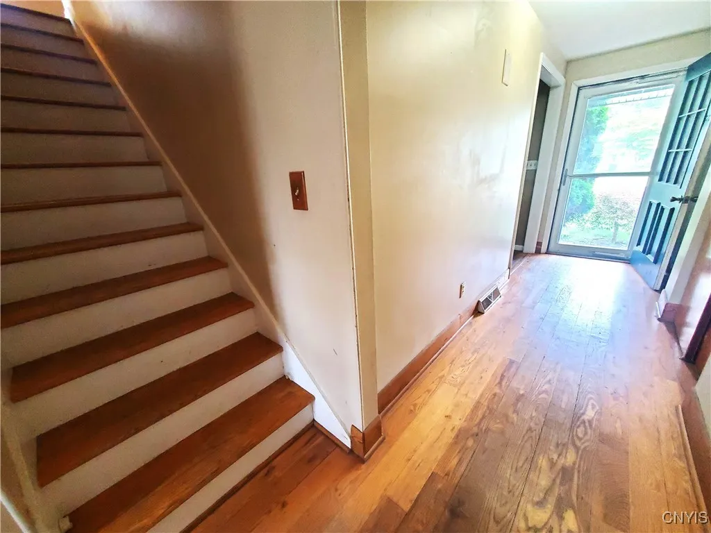 Hardwood staircase is  located between the rear living room wall and kitchen wall.
