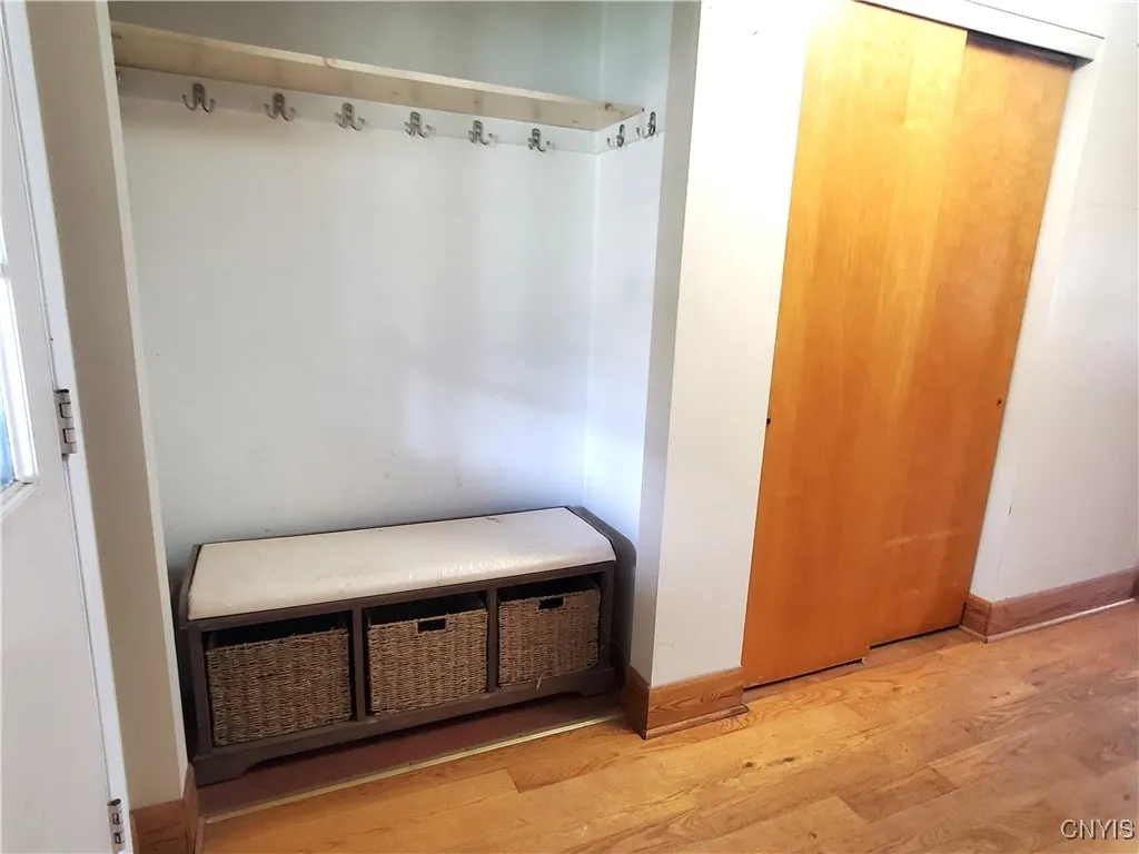 Foyer with hardwood floors has two closets